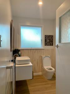 カイコウラにあるKaikōura Peaks eMotelの白いトイレと窓のあるバスルーム +13枚の写真