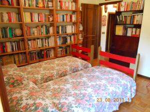 a bedroom with two beds in front of book shelves at B&B La Pilastrina in Maranello