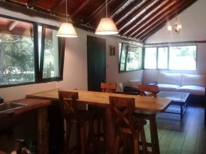 a dining room with a wooden table and chairs at Cabañas San Miguel in Villa Yacanto