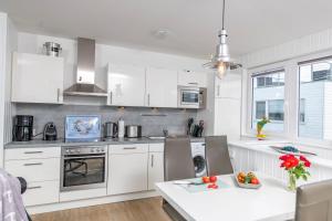 a kitchen with white cabinets and a white counter top at Schwimmendes Haus Sea Breeze in Olpenitz