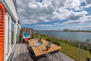 a deck with a table and chairs and a view of the water at Aquamarina in Olpenitz