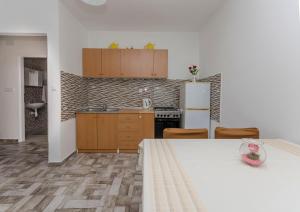 a kitchen with a table and a refrigerator at Apartments Mila II in Tribunj