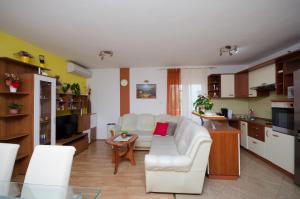 uma sala de estar com um sofá branco e uma cozinha em Apartments Mirjana em Lopar