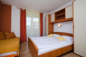 ein kleines Schlafzimmer mit einem Bett und einem Fenster in der Unterkunft Apartments Mirjana in Lopar