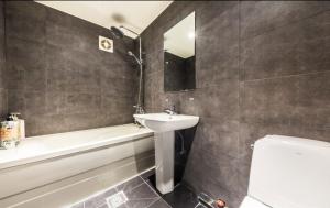 a bathroom with a sink and a tub and a toilet at Gugi Motel in Seoul