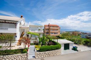 Blick auf ein Haus von der Straße in der Unterkunft Apartments Mirjana in Lopar