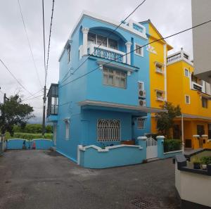 un edificio azul y amarillo con balcón en JiuZhiAn Apartment, en Wujie