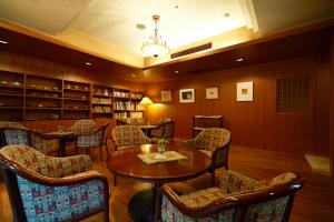 a library with chairs and a table in a room at Hotel Kazahaya in Hita