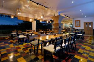 a restaurant with tables and chairs on a colorful floor at Koa D Surfer Hotel in Canggu