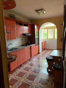 cocina con armarios rojos y suelo de baldosa en 159 Проспект Добровольского Большая 3-х комнатная квартира в Одессе, en Odessa