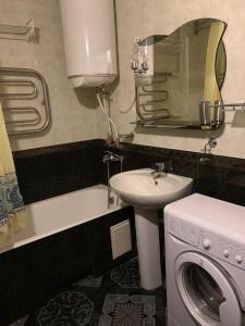 Un baño con lavabo y lavadora. en 159 Проспект Добровольского Большая 3-х комнатная квартира в Одессе, en Odessa