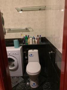 Un baño con inodoro y lavadora. en 159 Проспект Добровольского Большая 3-х комнатная квартира в Одессе, en Odessa 9 fotos más