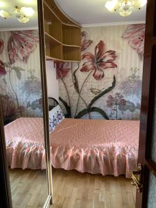 Un dormitorio con una cama rosa con flores en la pared en 159 Проспект Добровольского Большая 3-х комнатная квартира в Одессе, en Odessa