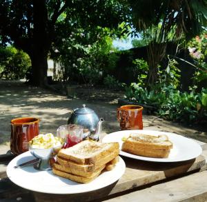 a table with two plates of bread and toast at Breeze Guest House in Trincomalee