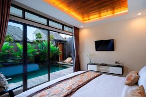a bedroom with a view of a swimming pool at La Paradis Villa in Canggu