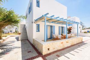 a white house with a blue pergola on a patio at Kostantis Vacation Home 1 in Ambelas