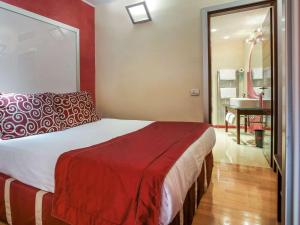a bedroom with a bed and a bathroom with a sink at La Griffe Hotel Roma in Rome