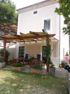 a house with a patio with a wooden umbrella at B&B Mazzarella in San Mauro Cilento