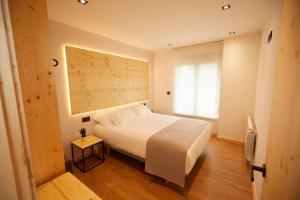 a bedroom with a white bed and a window at Apartamentos Arumes do Mar e Montaña - Viveiro in Viveiro