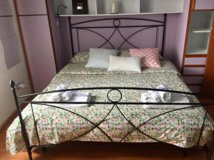 a small bedroom with a bed with a purple wall at La Casa di Chiara in Salerno