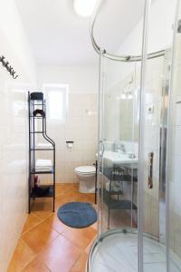 a bathroom with a shower and a toilet and a sink at Moments Apartment in Dekani