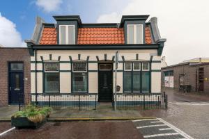 a white and black house with an orange roof at Oosterhouse in Zandvoort +8 photos