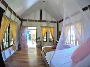 a bedroom with a bed in a room with windows at Koh Jum Coral Bay Resort in Ko Jum