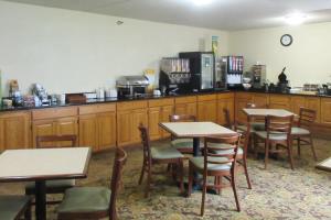 a restaurant with tables and chairs and a counter at Quality Inn & Suites in Alexandria