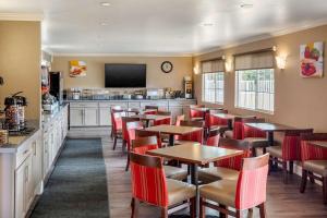 a restaurant with tables and chairs and a television at Comfort Inn Castro Valley in Castro Valley