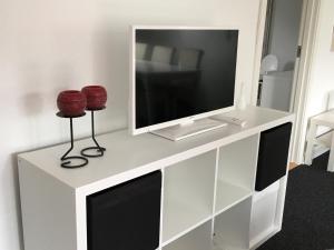 a white entertainment center with a tv on top of it at Give Family Apartment in Give