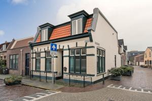 a white house with an orange roof on a street at Oosterhouse in Zandvoort