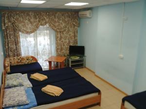 ハバロフスクにあるAlbatrosのベッドルーム1室(ベッド1台、テーブル、窓付)