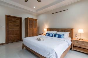 a bedroom with a large white bed with blue pillows at AnB poolvilla 2BR with private beach in pratamnak in Pattaya South