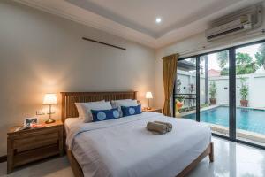 a bedroom with a bed and a swimming pool at AnB poolvilla 2BR with private beach in pratamnak in Pattaya South