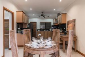 a dining room with a table and chairs and a kitchen at AnB poolvilla 2BR with private beach in pratamnak in Pattaya South