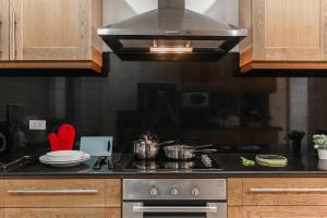 a kitchen with a stove with pots and pans at AnB poolvilla 2BR with private beach in pratamnak in Pattaya South