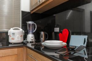 a kitchen counter with a stove top with a laptop on it at AnB poolvilla 2BR with private beach in pratamnak in Pattaya South