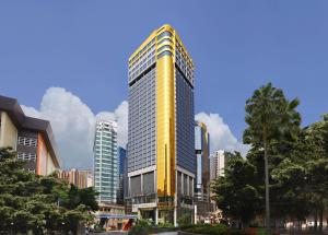 a tall yellow building in a city at Regal Hongkong Hotel in Hong Kong