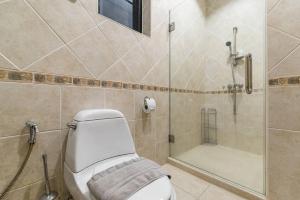 a bathroom with a shower and a toilet and a glass shower at AnB poolvilla 2BR with private beach in pratamnak in Pattaya South