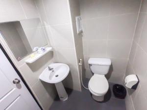 La petite salle de bains est pourvue de toilettes et d'un lavabo. dans l'établissement Inspire House Hotel, à Chiang Mai