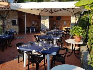 a restaurant with blue tables and chairs and an umbrella at Campeggio Gianna Golfo dei Poeti in Lerici