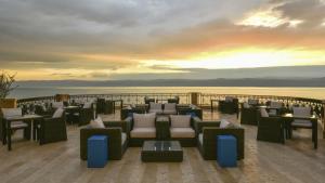 
a dining room table with chairs and umbrellas at Kempinski Hotel Ishtar Dead Sea in Sowayma
