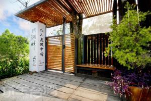- une terrasse couverte en bois avec un banc en bois dans l'établissement Yue Lake Backpackers, à Yuchi