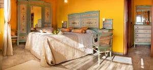 sypialnia z łóżkiem, krzesłem i lustrem w obiekcie Il Borgo B&B w mieście Castellinaldo
