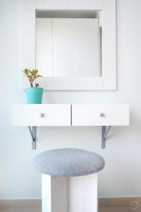 a white dressing table with a mirror and a stool at MOUSELIS APARTMENTS in Kalymnos