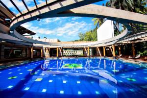 - une grande piscine d'eau bleue dans un bâtiment dans l'établissement Malligi,Hampi, à Hospet
