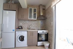 uma cozinha com uma máquina de lavar roupa e um frigorífico em MOUSELIS APARTMENTS em Kalymnos