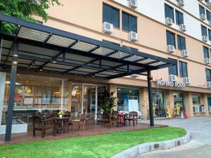 een patio met tafels en stoelen voor een gebouw bij Inspire House Hotel in Chiang Mai