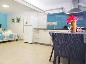 cocina con mesa, sillas y nevera en Sea Front Studio - Porto Boufalo - Evia, en Boufalo