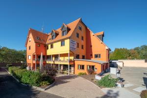 un edificio que está al lado de un estacionamiento en Hôtel Le Verger De Bischwiller, en Bischwiller